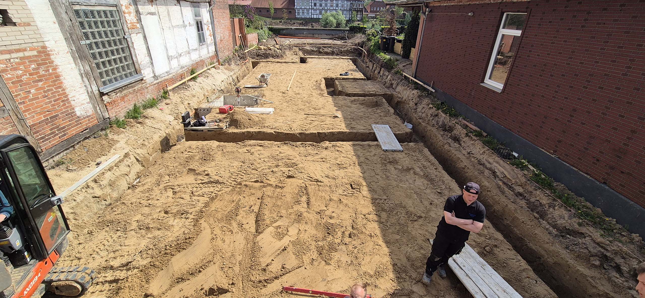 Bauprojekt in Hoya. Ein Bauarbeiter steht in der ausgehobenem Fundamentgrube.
